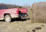 Truck picking up bale.