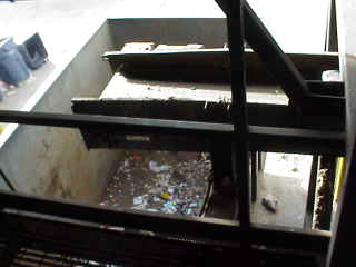 Return conveyor belt over trash dumpster.